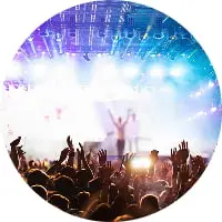 コンサートやライブ会場で手を挙げる観客とステージ照明の様子。